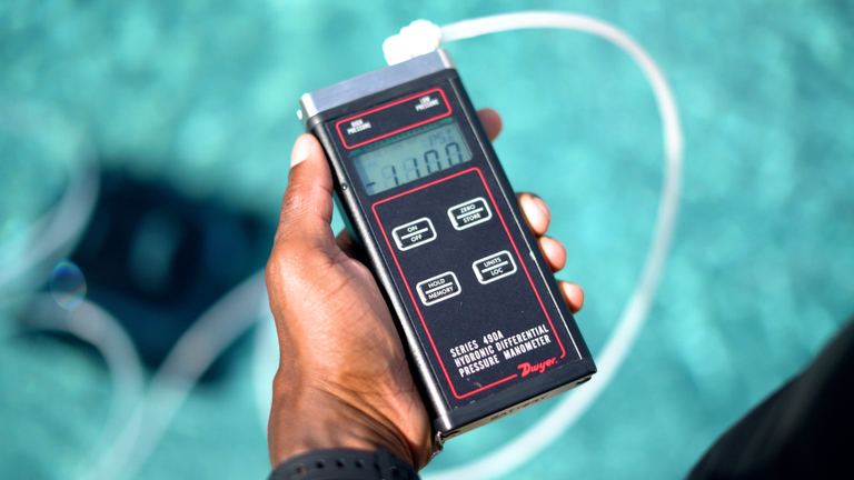 Beatbot AquaSense 2 Hand Holding Digital Manometer Near Pool