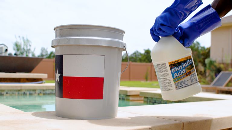 Champion Muriatic Acid Gloved Hands Lifting Jug Beside Bucket